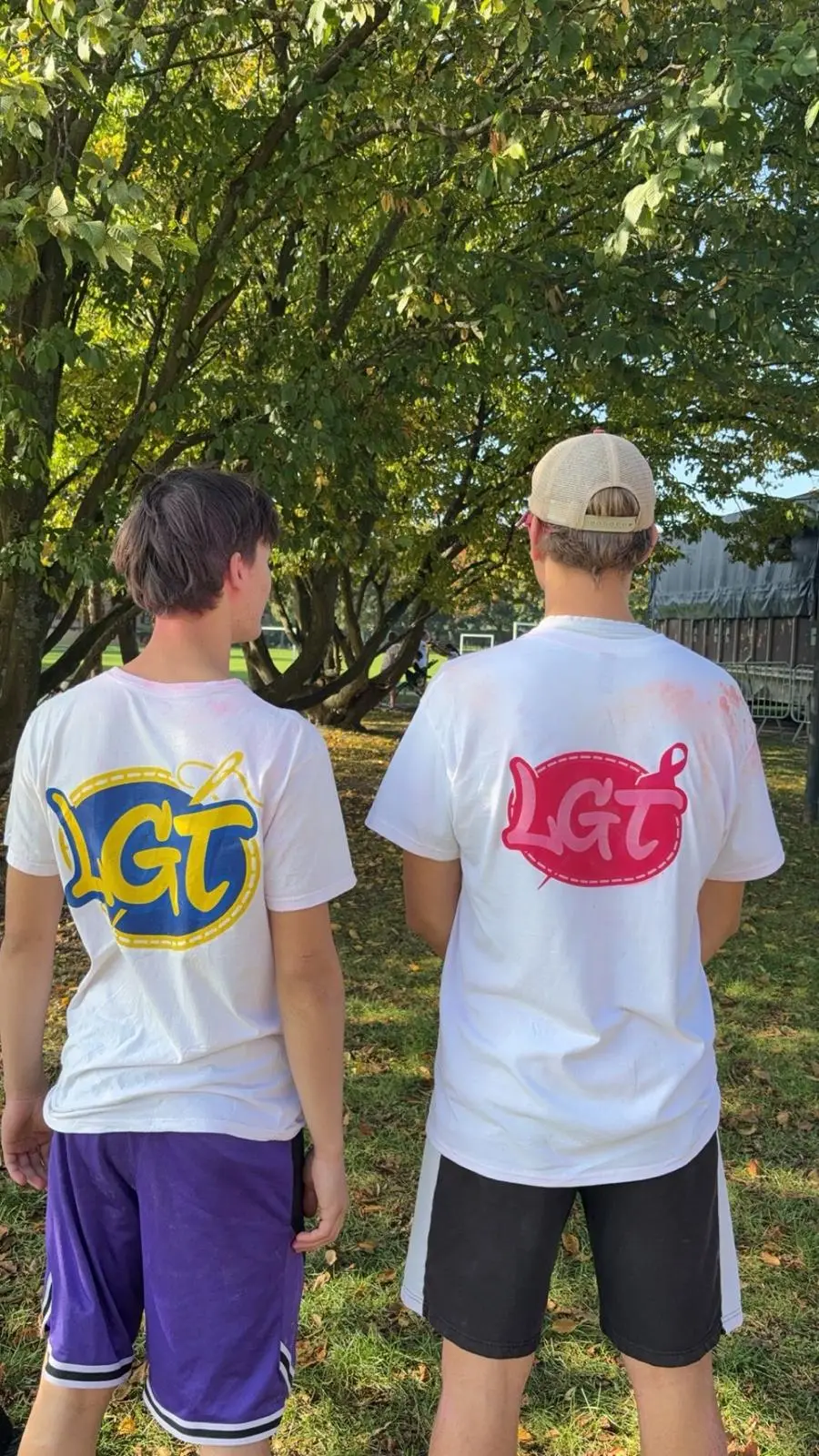 Deux membres de l'association, de dos, portent les t-shirts au logo LGT bleu et jaune.